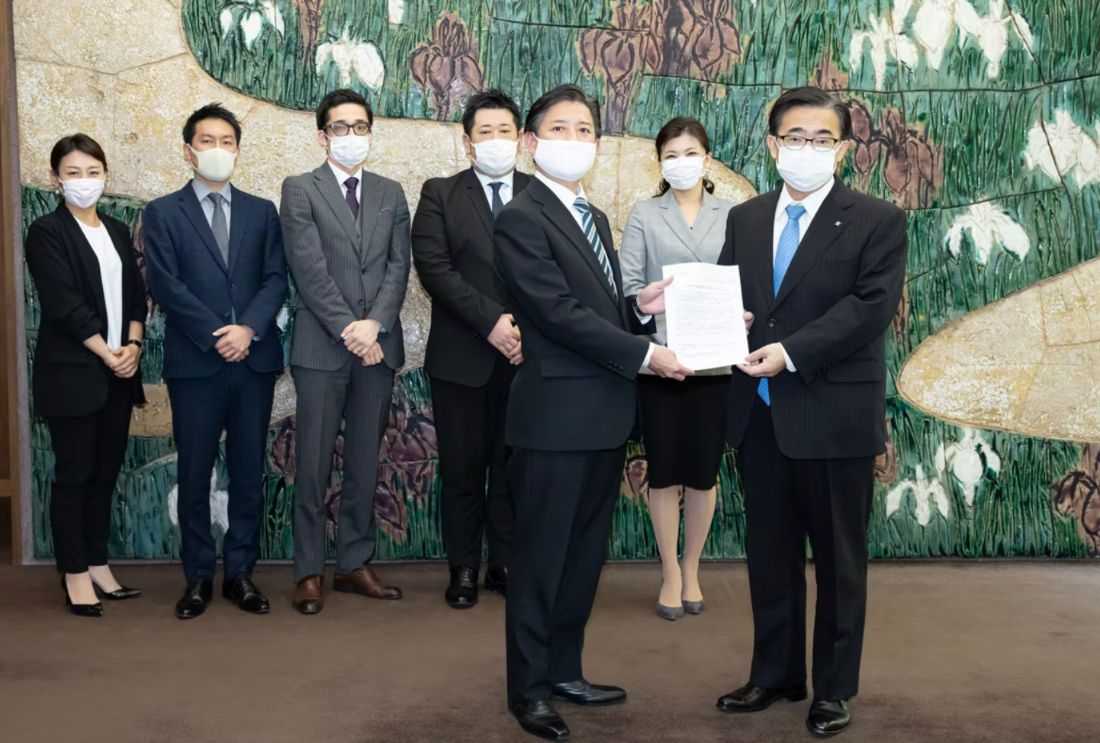 愛知県庁にて、協議会理事が愛知県知事へ陳情書を手渡す様子